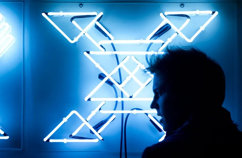 White neon X with viewer in front of it